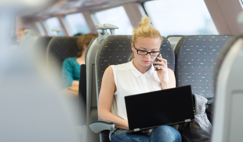 Frau telefoniert mit Handy im Zug